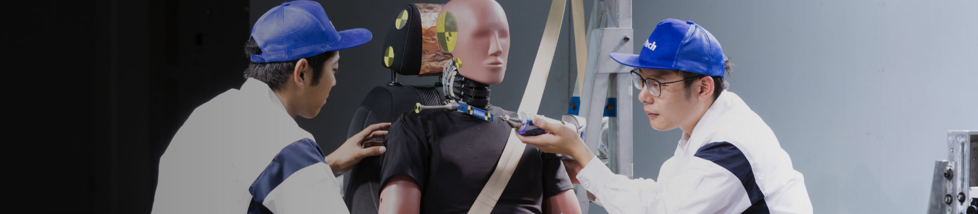 Two employees checking the human dummy set in the test machine