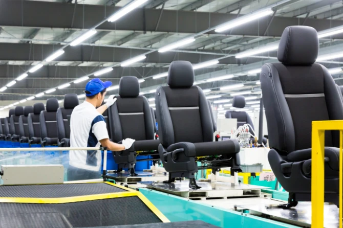 Picture of a man touching a seat on a production line