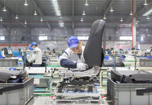 An employee of a sheet production line assembles parts on a sheet frame.