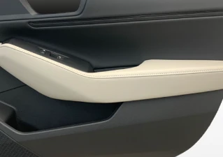 A close-up view of the door trim with the white armrests.